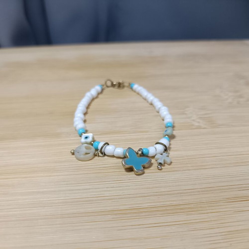 Bracelet with blue and white beads, peace sign and charms