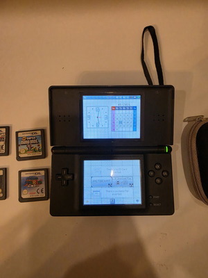 Nintendo DS Lite console with 4 games and carrying case