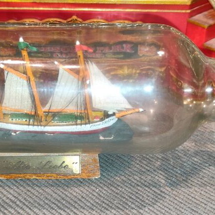 Ship in a bottle used with sealed top and wooden base