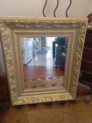 Baroque wall mirror with carved gold frame and embossed motifs