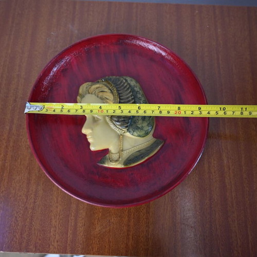 Decorative wall plate used with embossed female profile on burgundy background