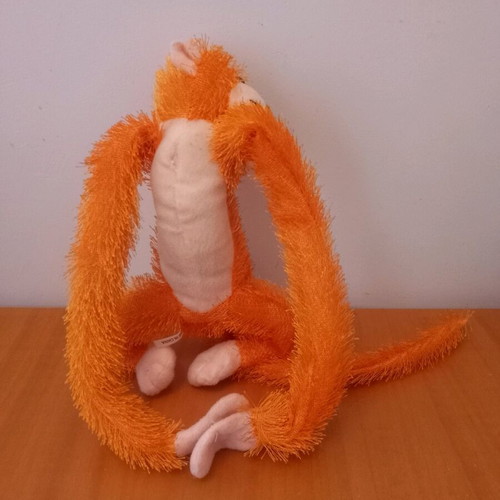 Stuffed monkey with scratches like new, orange color
