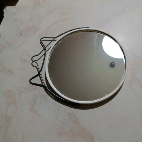 Small round tabletop mirror used with integrated stand
