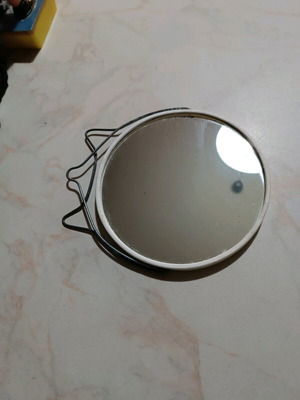 Small round tabletop mirror used with integrated stand