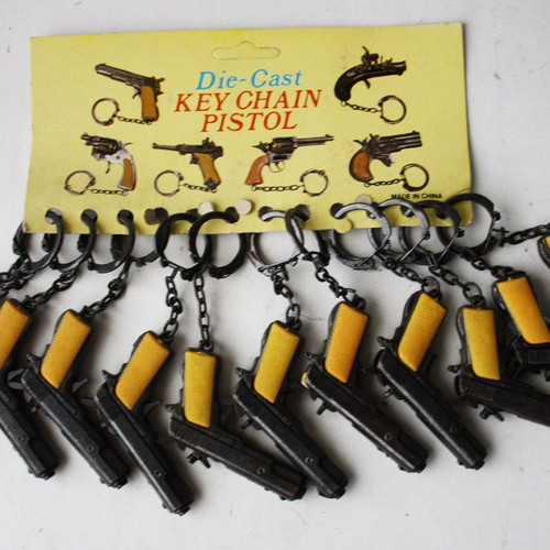 Card with 12 vintage 80's Colt 45 metal pistol keychains new