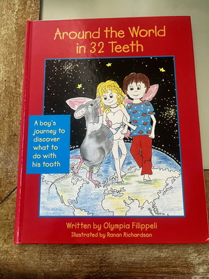 Around the World in 32 Teeth Hardcover book, signed by Olympia Filippeli