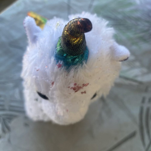 Unicorn plush toy with colorful shiny wings and metallic purple details