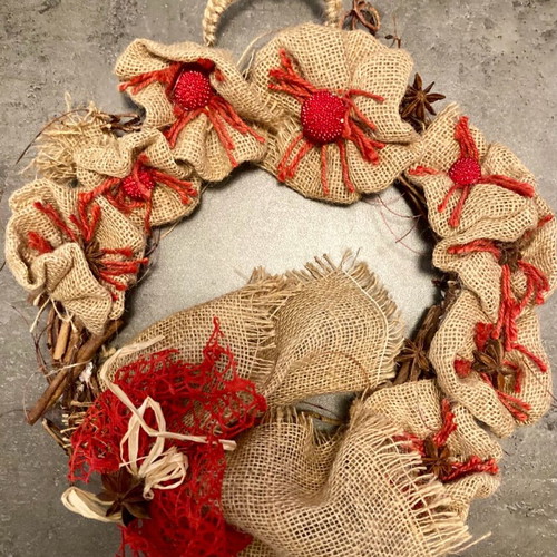 Christmas wreath made of natural materials with knitted handle