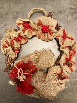 Christmas wreath made of natural materials with knitted handle