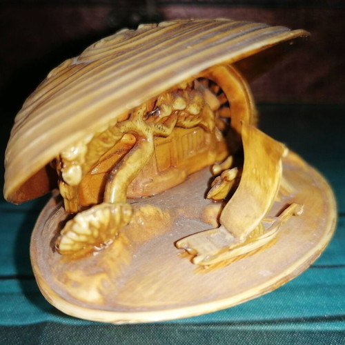 Vintage carved shell with dragon and scenic details