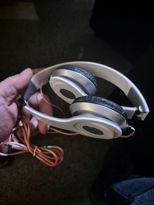 Foldable on-ear headphones used, white with silver details