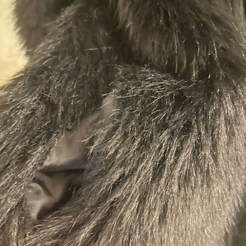 Long-haired fur used, black synthetic with pockets