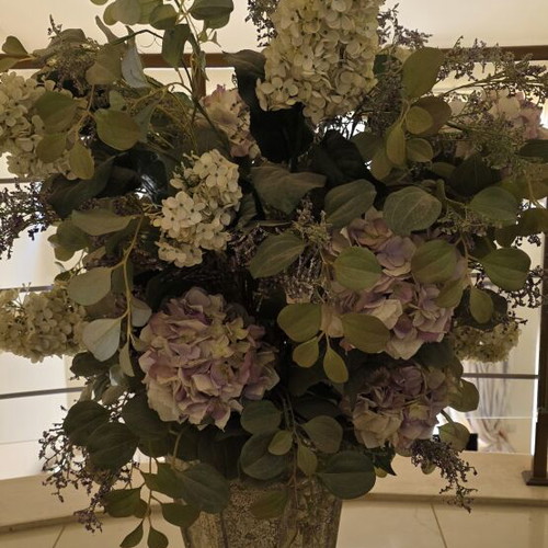 Artificial flower arrangement with hydrangeas and eucalyptus in clay floor vase