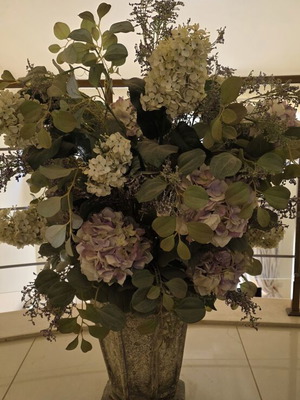 Artificial flower arrangement with hydrangeas and eucalyptus in clay floor vase