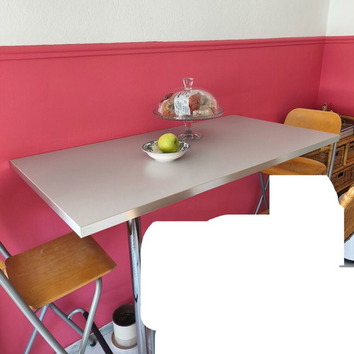 Bar table with 2 high stools used, gray surface and chrome legs