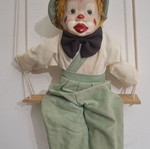 Porcelain clown doll on wooden swing, vintage collectible