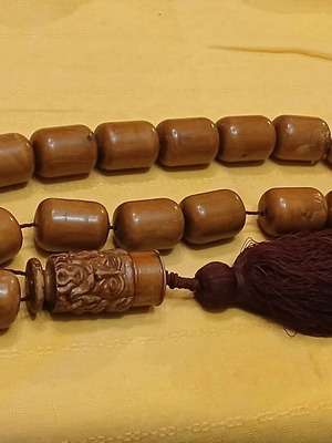 Wooden komboloi used with carved priest figure