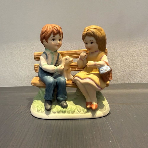 Porcelain decoration with two children on bench like new