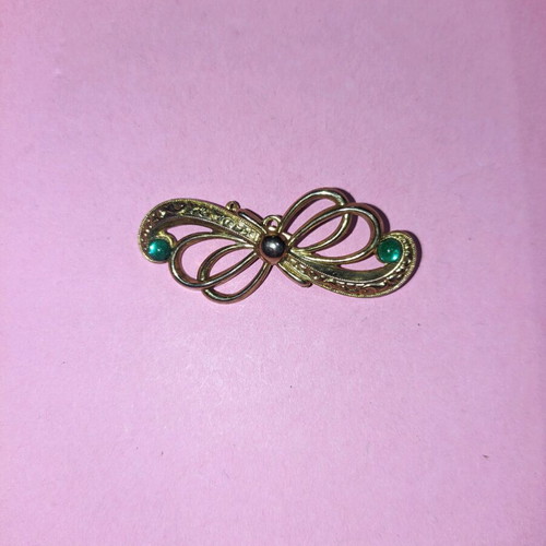 Bow-shaped pin new, gold color with green stones