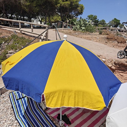 Beach umbrella used with carrying case and sand anchor