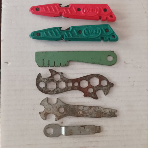 Various tools used including cable strippers, vintage bicycle wrench, glass cutter