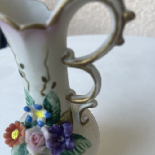 Vintage ceramic pitcher with embossed flowers used