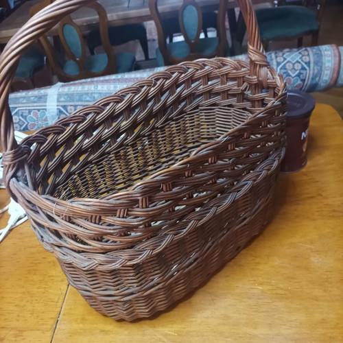 Handmade dark brown wicker basket with high arched handle