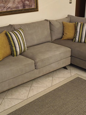Corner sofa like new in grey/beige taupe color with decorative pillows