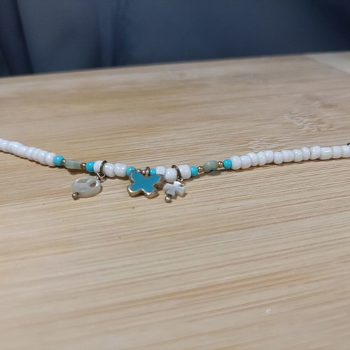 Bracelet with blue and white beads, peace sign and charms