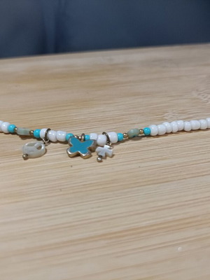 Bracelet with blue and white beads, peace sign and charms