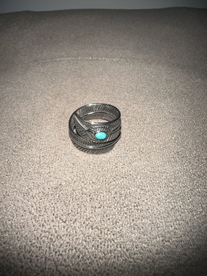 Men's ring with embossed feather design and blue stone used