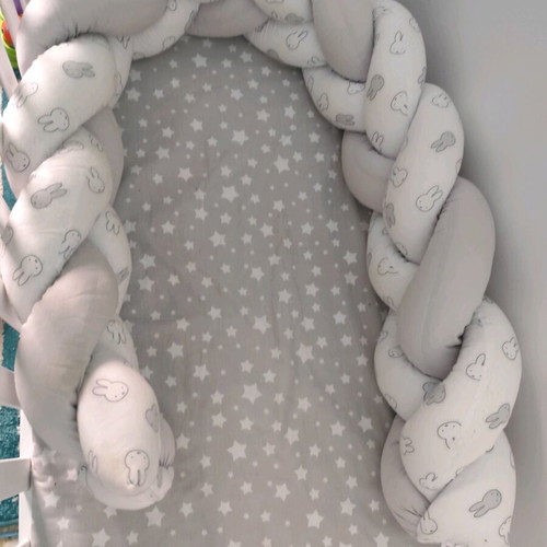 Baby braided crib bumper used in gray and white
