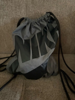 Nike sports backpack with straps and side pocket, black and grey