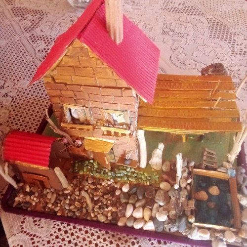 Handmade decorative house with cardboard, pebbles and driftwood, new