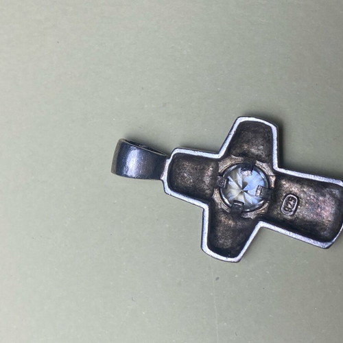 Silver cross used with stone