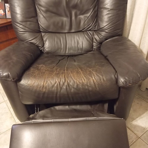 Leather recliner armchair used with wear on seat and footrest