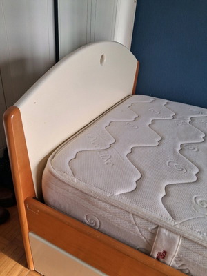 Wooden bed used with sliding second mattress and metal frame
