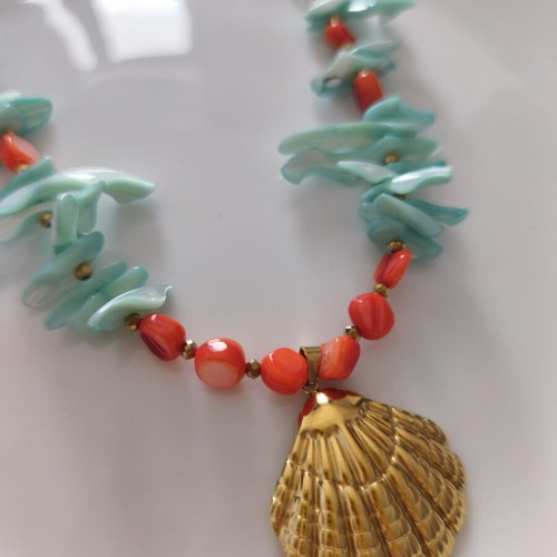 Necklace with shell chips and steel clam pendant