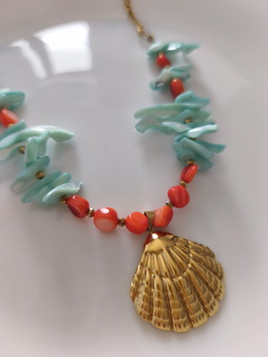 Necklace with shell chips and steel clam pendant