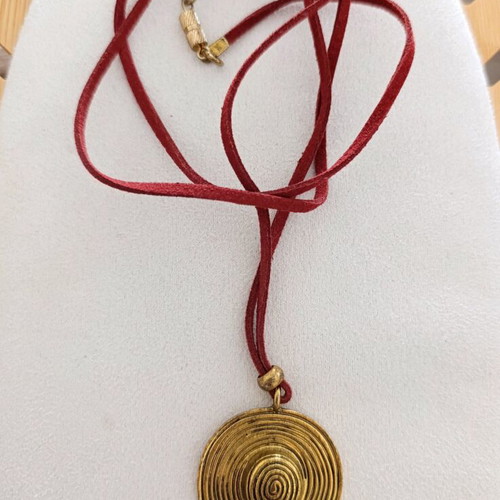 Long necklace with burgundy strap and gold vintage hat pendant