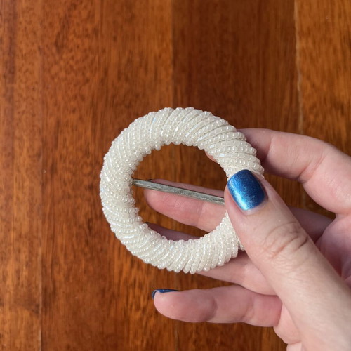 Belt buckle with small white beads