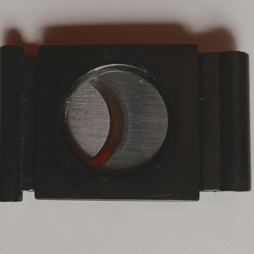 Black plastic cigar cutter used with metal cutting edges
