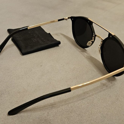 Modern sunglasses with gold frame and black round lenses