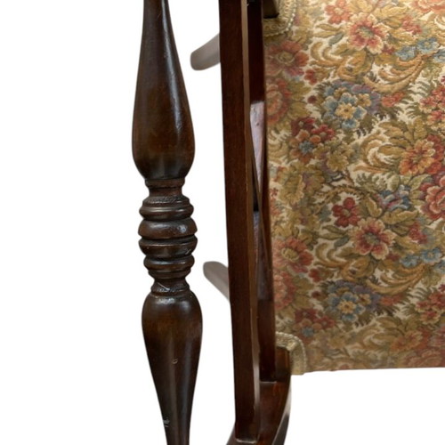 Wooden stool with carved high arms