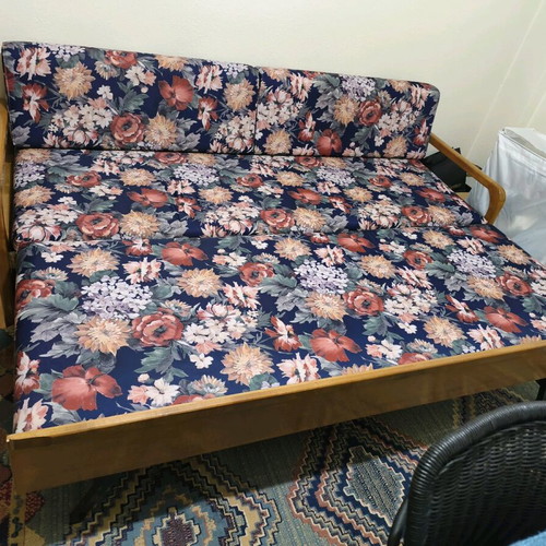Three-seater sofa with pull-out bed and floral upholstery