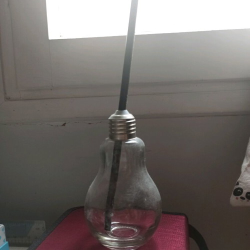 Glass cup shaped like a light bulb used with straw