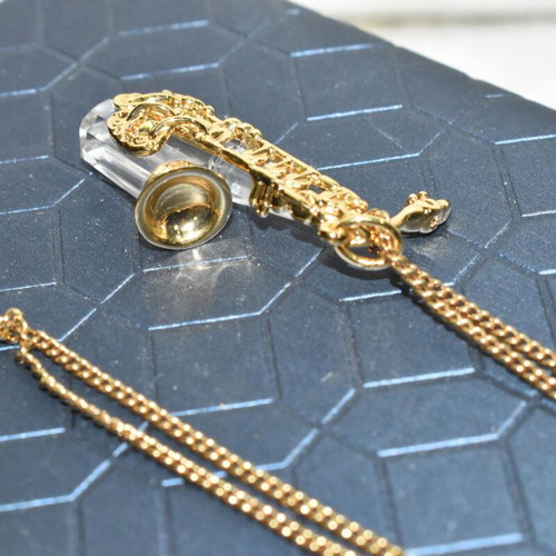 Swarovski necklace with saxophone pendant and crystal like new, gold plated