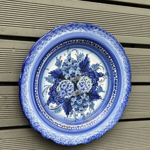 Handmade ceramic wall plate used with blue floral motif