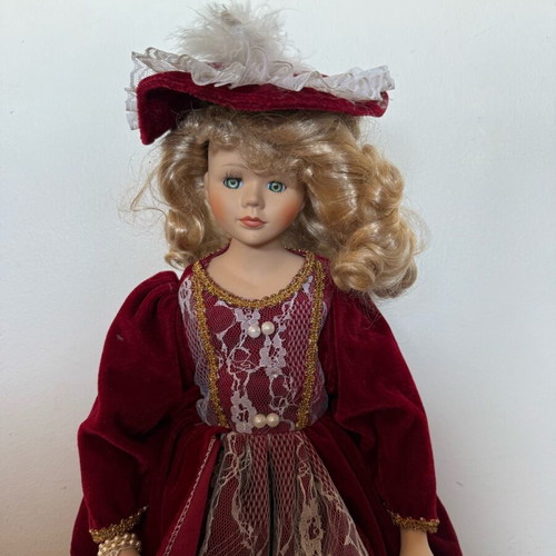 Porcelain doll with burgundy velvet dress like new