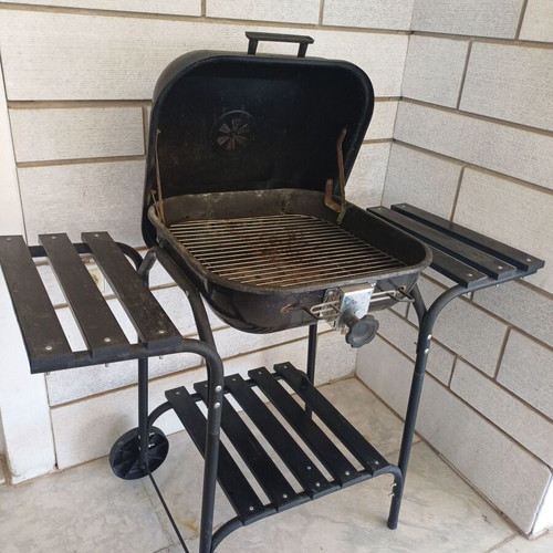 Charcoal grill used, wheeled with shelves and tools
